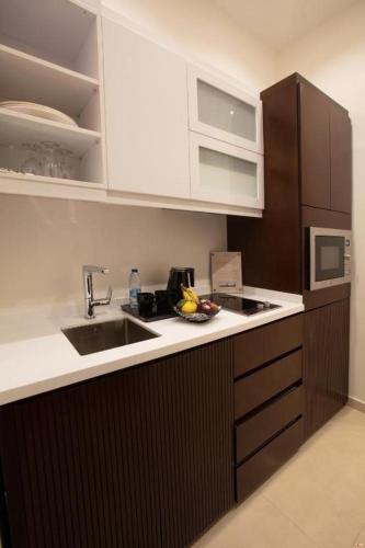 a kitchen with a sink and a microwave at Seas Hotel Amman in Amman