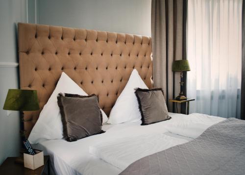 a bedroom with a large bed with a large headboard at Boutique Hotel Villa Sarah in Düsseldorf