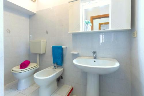 Baño blanco con aseo y lavamanos en Appartamento Attico Vespucci - MyHo Casa, en Tortoreto Lido