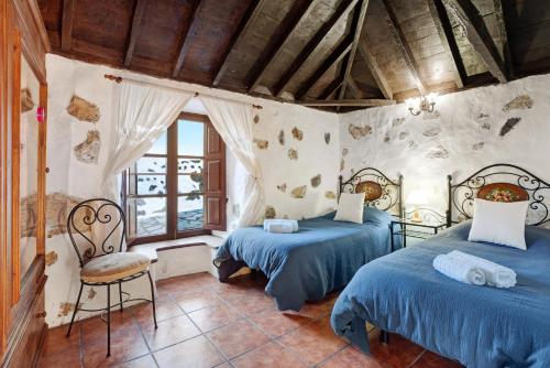 um quarto com 2 camas e uma cadeira em Cassalive em Mazo