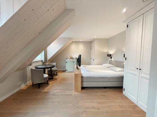 ein Schlafzimmer mit einem Bett und einem Schreibtisch in einem Zimmer in der Unterkunft Hello Zeeland - Studio's Zuidstraat 1 in Domburg