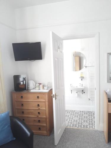 a room with a bathroom with a sink and a door at Montrose Guest House in Minehead