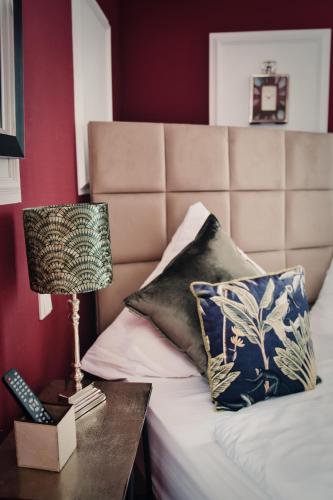 a bedroom with a bed with a lamp and a table at Boutique Hotel Villa Sarah in Düsseldorf