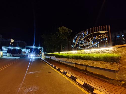 a city street at night with a neon sign at Banana Homestay Kuching - P' Residence in Kuching
