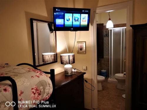 een slaapkamer met een tv aan de muur en een badkamer bij Villa con piscina Assisi in Assisi