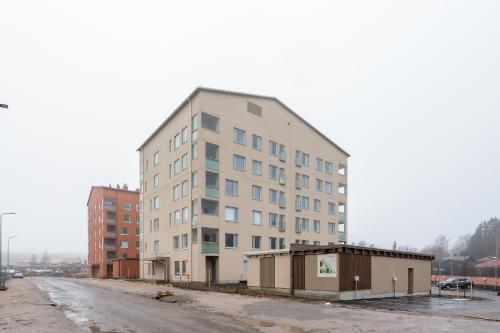 un edificio blanco alto al lado de una calle en Hiisi Homes Espoo Finnoo, en Espoo