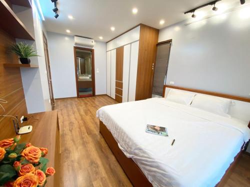 a bedroom with a bed and a table with flowers at Luxe Paradise Residence Trinh Cong Son in Hanoi