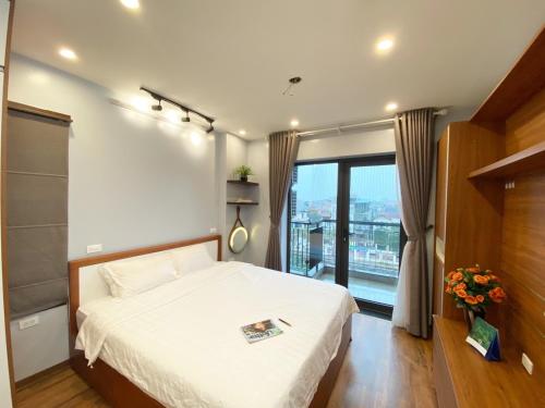 a bedroom with a bed and a large window at Luxe Paradise Residence Trinh Cong Son in Hanoi