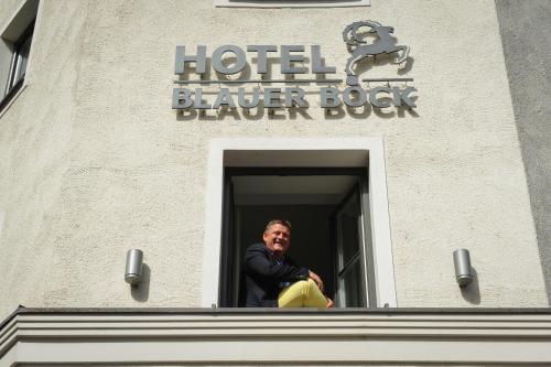 a man looking out of a window of a building at Hotel Blauer Bock in Munich