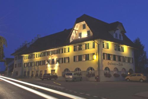 a large white building with cars parked in front of it at Gasthaus zum Rössli in Triengen