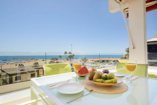 stół z miską owoców i widokiem na plażę w obiekcie Ático Apartamento Las Burras Playa w mieście San Agustin