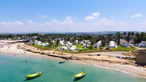 an aerial view of a beach with two boats in the water at Dor village in Dor