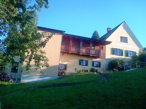 a large white house with a balcony on the side of it at FerienAppartments Landhaus FühlDichWohl in Fehring