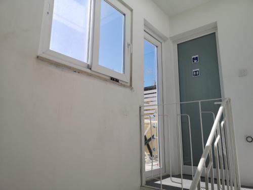 a hallway with a window and a staircase at Dghajsa GUEST HOUSE in Senglea