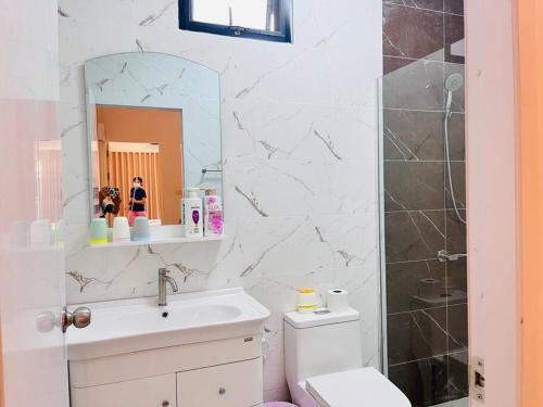 a bathroom with a sink and a toilet and a mirror at BKK Villa/Huaikwang China Twon in Bangkok