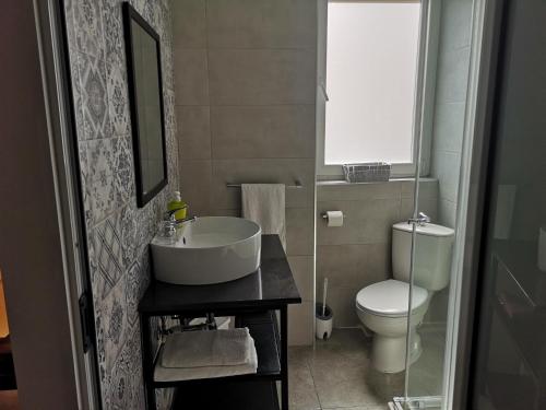 a bathroom with a sink and a toilet at Dghajsa GUEST HOUSE in Senglea