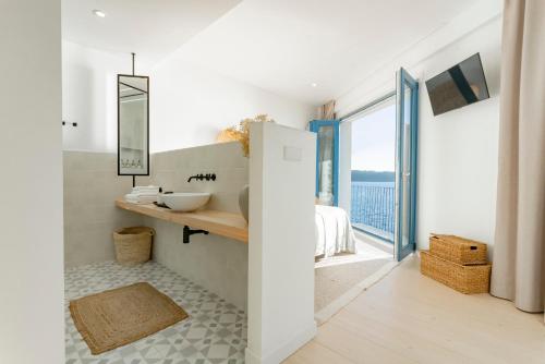 baño con lavabo y ventana grande en O mar de preciosa en Camariñas