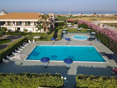 uma vista sobre uma piscina com guarda-sóis e cadeiras em GH Baraka Village em Scoglitti