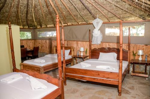 sypialnia z 2 łóżkami i namiotem w obiekcie Giraffe Hills Mara Camp w mieście Masai Mara