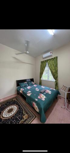 1 dormitorio con 1 cama con manta verde y ventana en Casa Harmony, en Tanah Merah