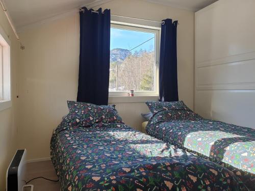 a bedroom with two beds next to a window at Holiday Rooms in Gol
