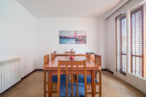 a dining room with a wooden table and chairs at Canet beach 3 in Canet de Mar