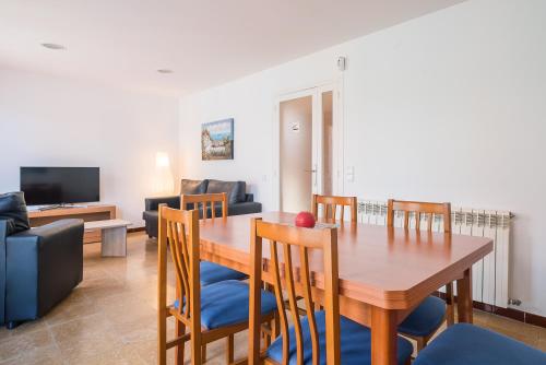a dining room and living room with a table and chairs at Canet beach 3 in Canet de Mar