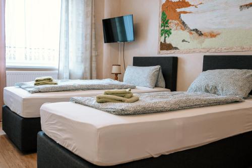 twee bedden in een kamer met handdoeken erop bij Dill Hotel in Ilsede