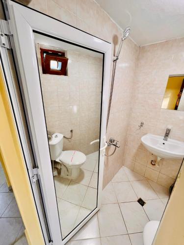 a bathroom with a shower and a toilet and a sink at Pop Аrt Bungalows in Primorsko