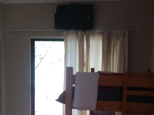 a bedroom with a bed and a window with a television at Royal Karoo Cottage unit 1 in Beaufort West