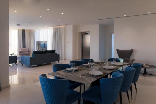a dining room with a table and blue chairs at Love Bridge Seaview Villas in Ayia Napa