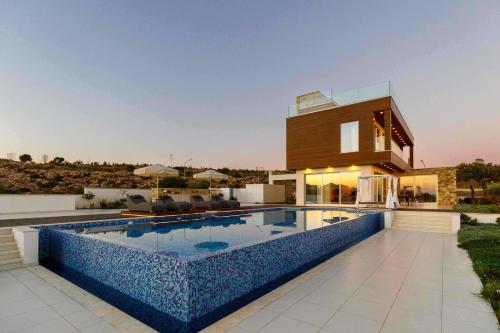a villa with a swimming pool in front of a house at Love Bridge Seaview Villas in Ayia Napa