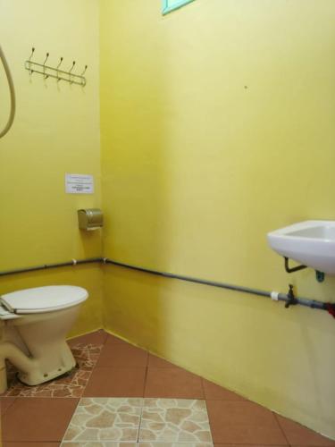 a bathroom with a toilet and a sink at Cheers Garden Chalet in Kampung Tekek