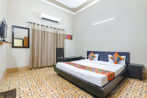 a bedroom with a large bed in a room at FabHotel Harmony in Colonelganj