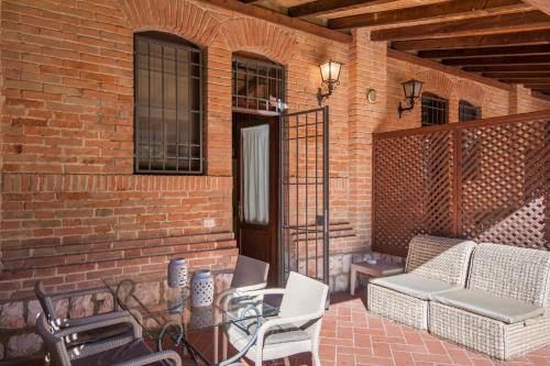 a patio with chairs and a table and a brick wall at Fattoria San Lorenzo in Grosseto