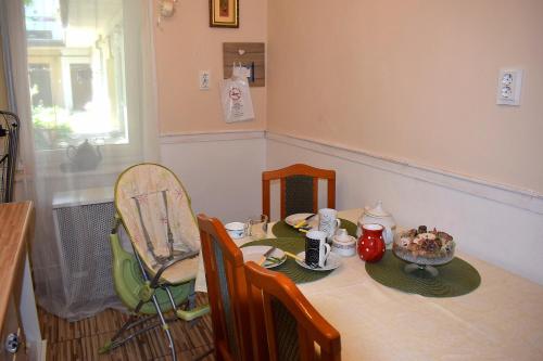 a dining room table and chairs with a table and a plate of food at Malomszeg Apartman in Pécs