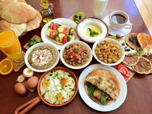 un tavolo ricoperto di piatti di prodotti per la colazione e bevande di Amman Palace Hotel ad Amman