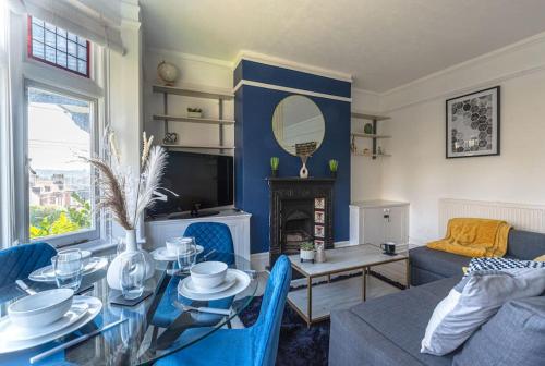 ein Wohnzimmer mit einem Tisch und ein Wohnzimmer mit einem Kamin in der Unterkunft Calverley Place -Long Stay Offer in Royal Tunbridge Wells