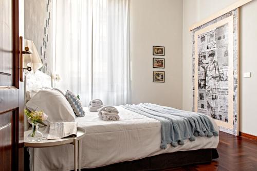 una camera da letto con un letto, un tavolo e una finestra di The Journalist House a Livorno
