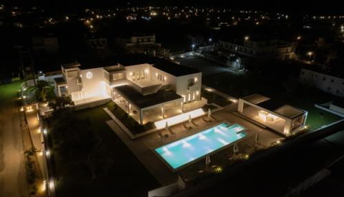 an aerial view of a house with a swimming pool at night at Tzanis Resort Skyros in Skiros