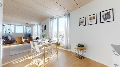 uma sala de jantar e sala de estar com mesa e cadeiras em Magnificent modern apartments in the city center em La Chaux-de-Fonds