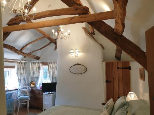 a bedroom with exposed beams and a bed in a room at The Old Mill Cottage in Okehampton