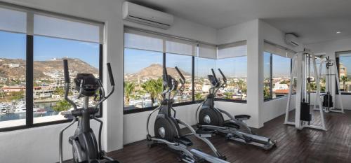 una palestra con macchine ellittiche in una stanza con finestre di Cabo San Lucas Marina Condos a Cabo San Lucas