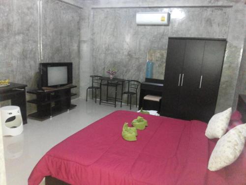 a bedroom with a pink bed with a stuffed animal on it at Bansappoori in Lamphun