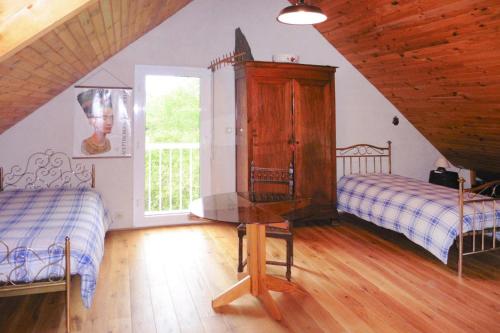 um quarto no sótão com 2 camas e uma mesa em Holiday Home Piriac-sur-Mer - NAT01027-F em Piriac-sur-Mer