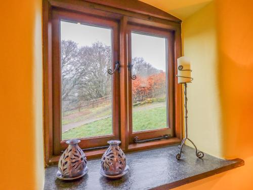 two vases sitting on a window sill in front of a window at Bradley Stables in Minehead