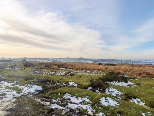 a snowy field with snow on the ground and a sky at Bradley Stables in Minehead