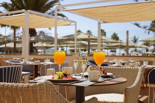a table with a plate of food and glasses of orange juice at Dreams Lanzarote Playa Dorada Resort & Spa in Playa Blanca