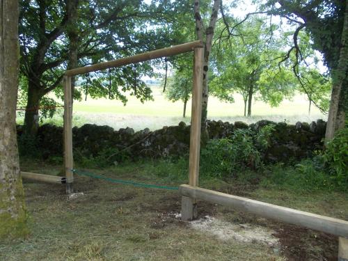 a wooden gate with a blue rope tied to a tree at Birch Lodge 12 with Hot Tub in Newton Stewart