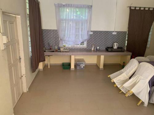 a kitchen with a table and a window in a room at Homestay Docmac Wakaf Che Yeh in Kota Bharu